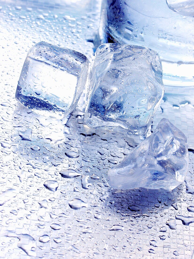 Ice cubes on metal platter with drops of water