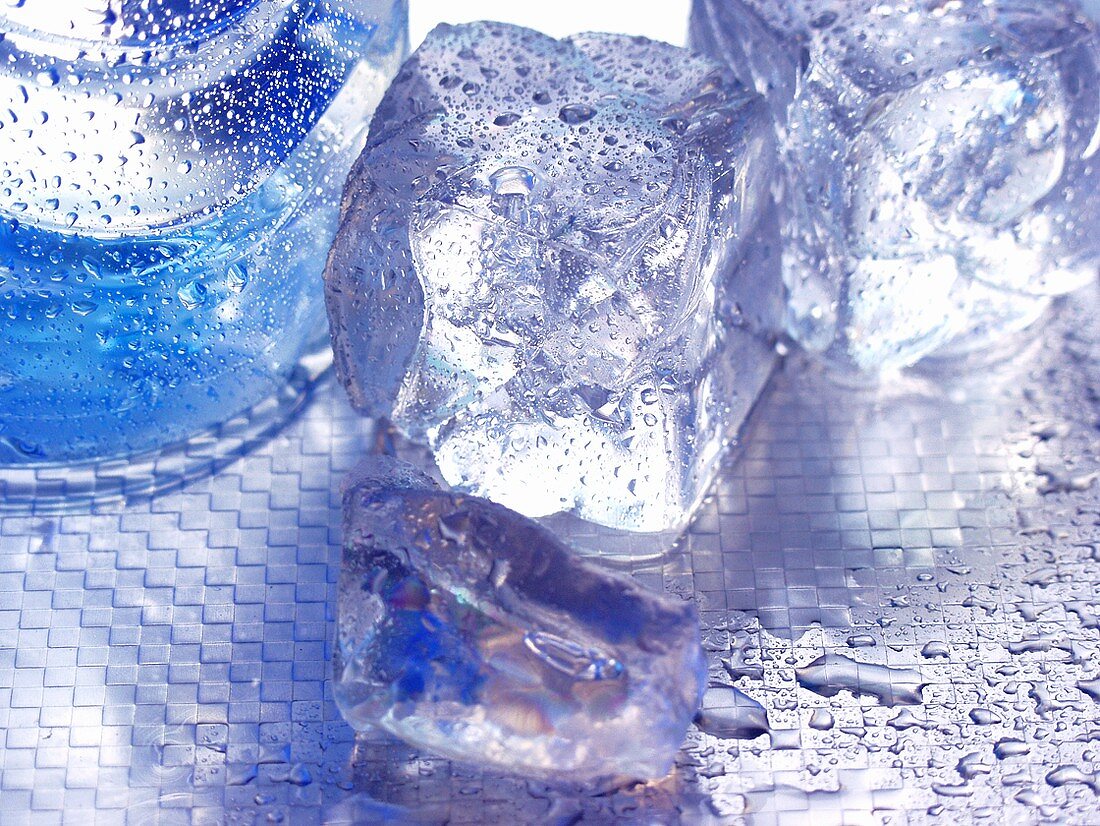 Eiswürfel neben Mineralwasserflasche