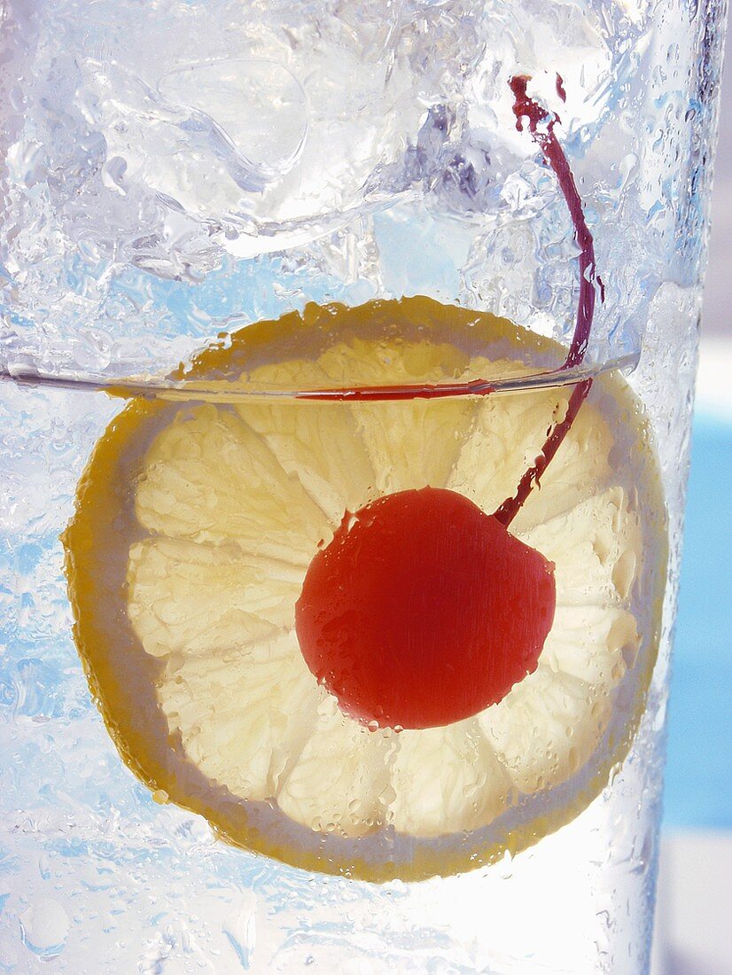 Drink with slice of lemon and cocktail cherry