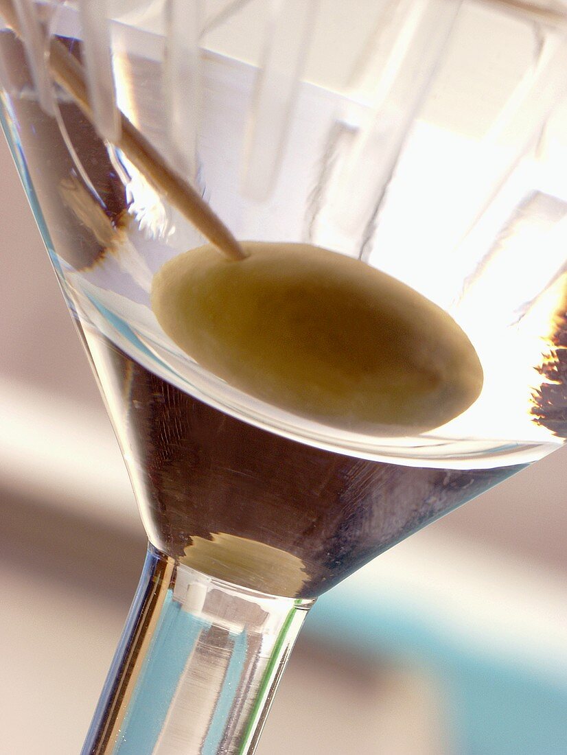 Martini with green olive in glass (detail)