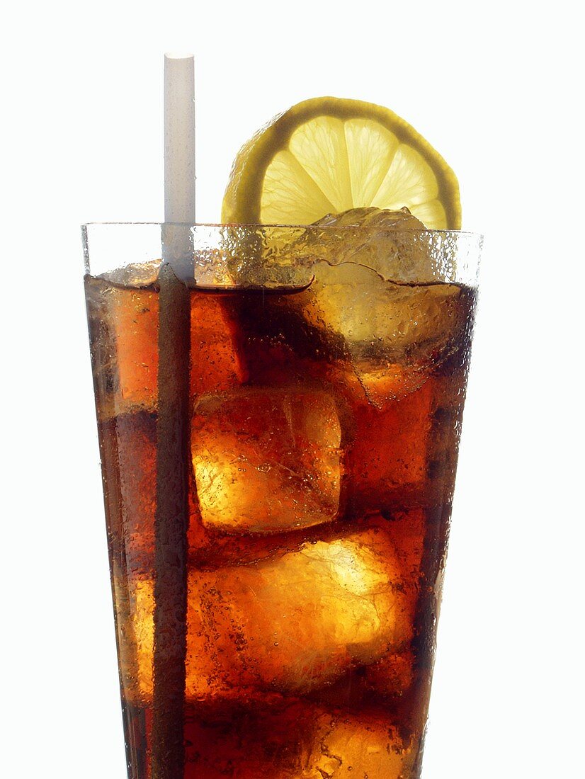 Cola mit Eiswürfeln, Zitronenscheibe und Strohhalm im Glas