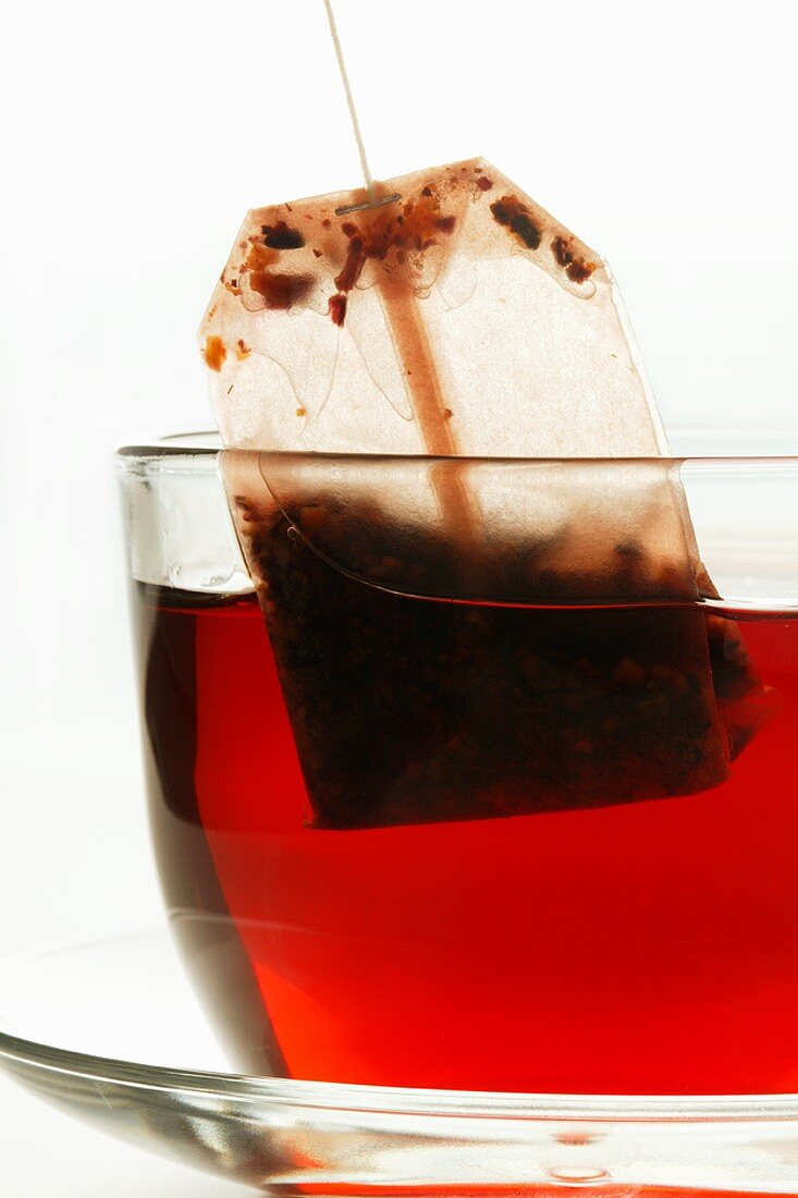 Removing tea bag from cup of hibiscus tea