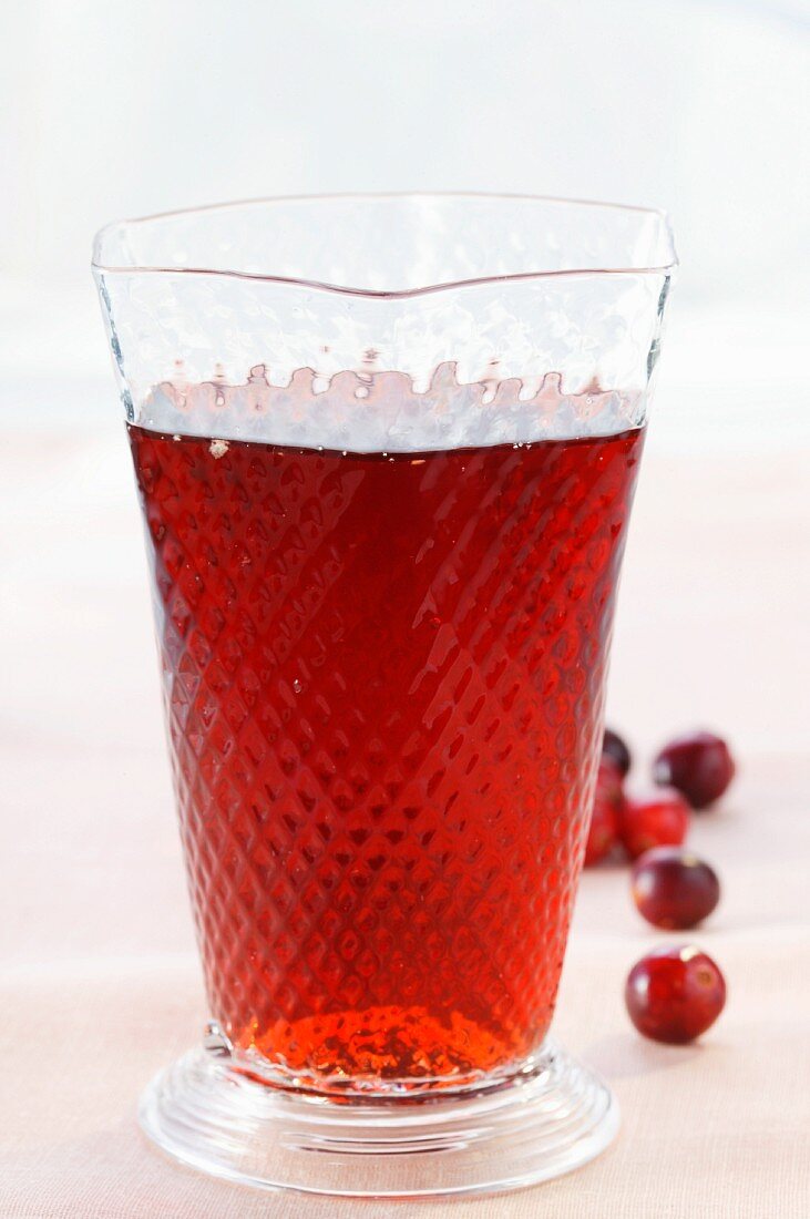 Cranberry juice in glass; fresh cranberries