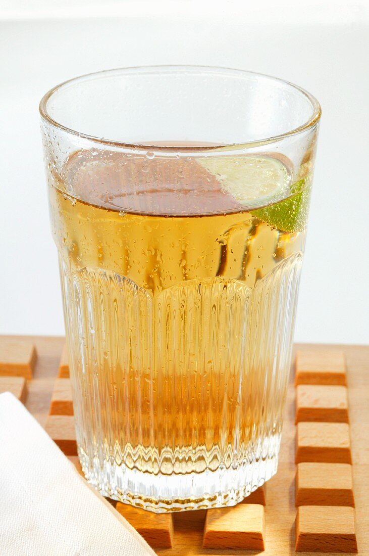 Apple juice with wedge of lime in glass