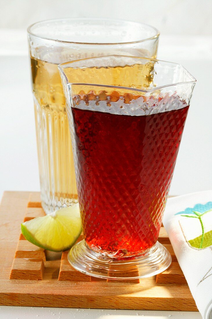 Apple juice and cranberry juice; wedge of lime