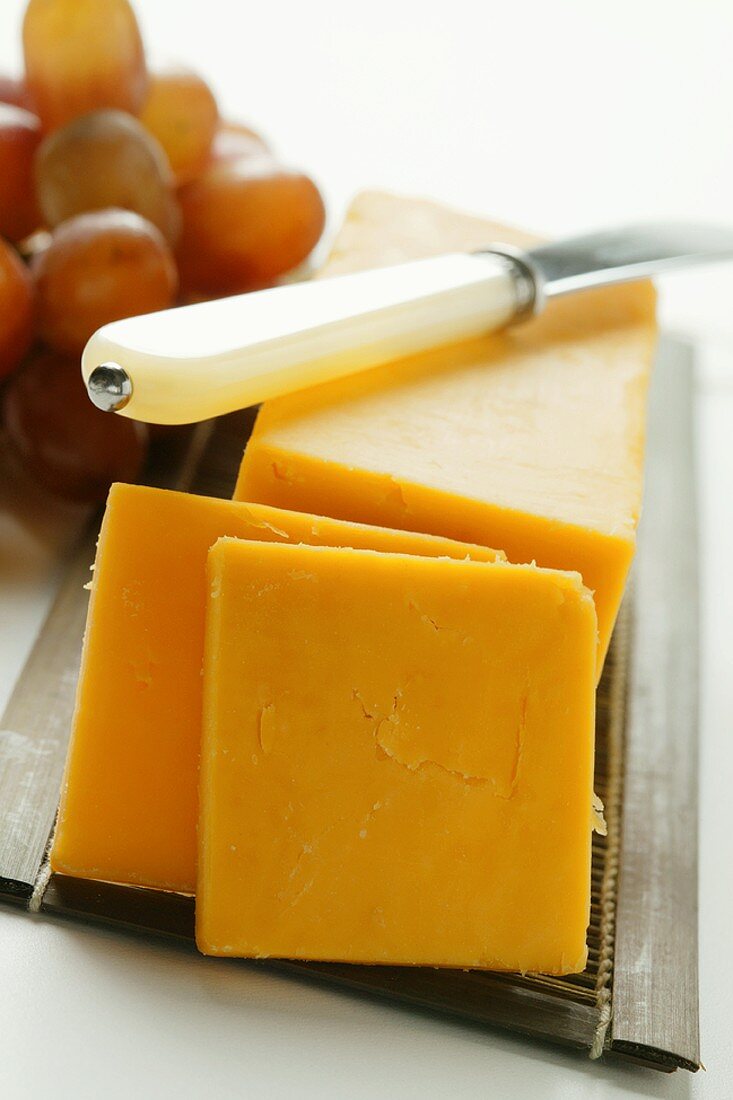 Extra Sharp Cheddar mit Käsemesser und Trauben
