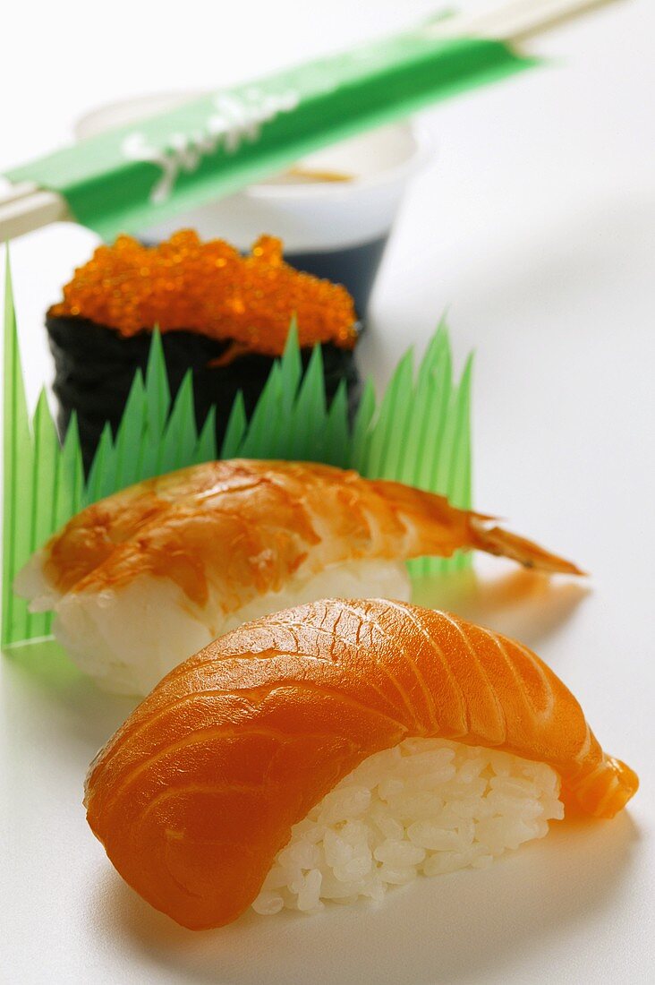 Sushi with salmon, shrimp and caviare; soy sauce