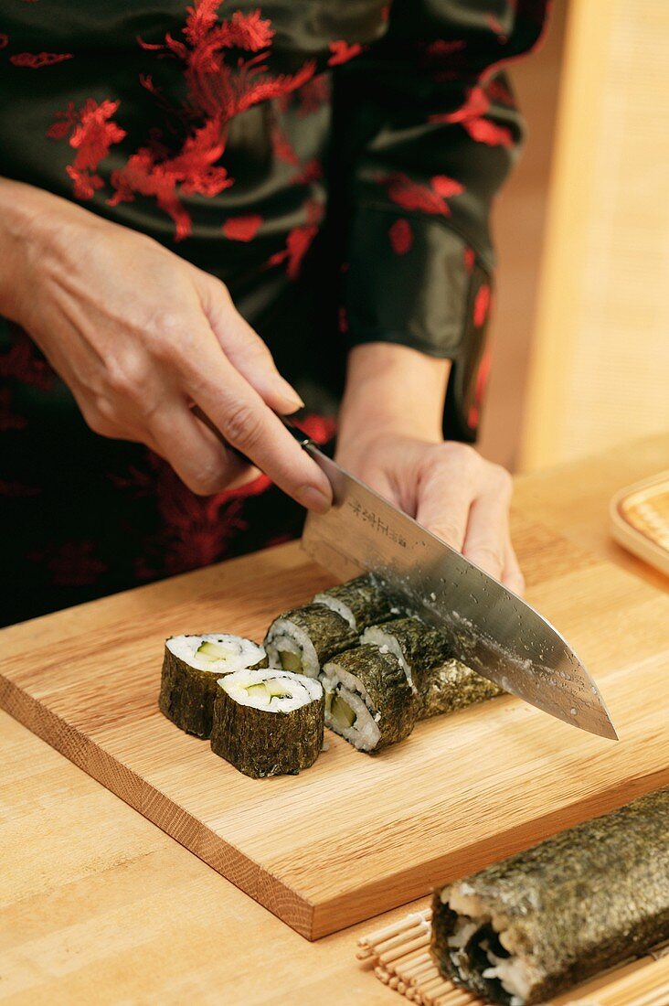 Gerollte Sushi in Stücke schneiden