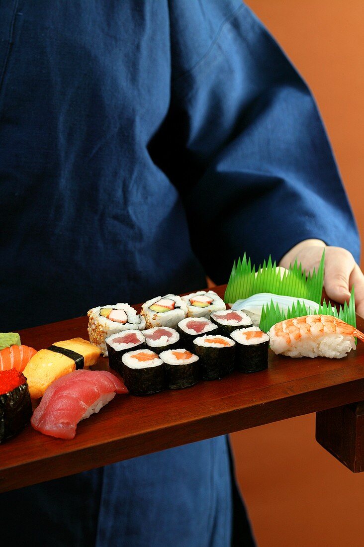 Person serving sushi platter