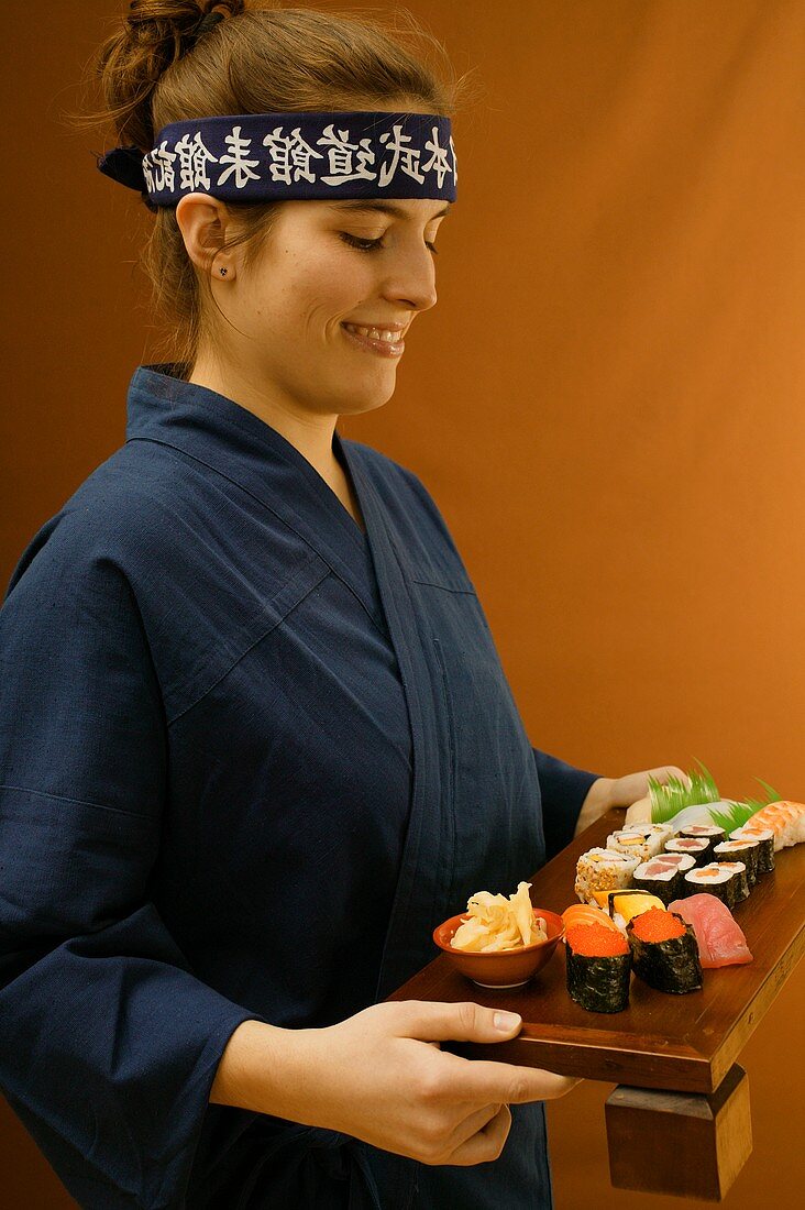 Woman serving sushi platter