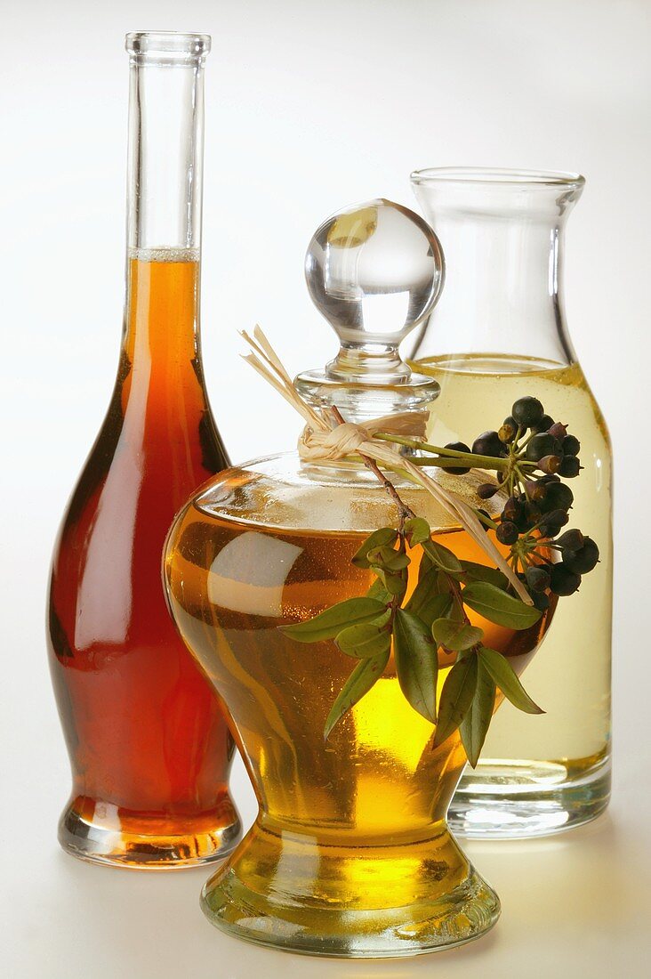 Olivenöl, Erdnussöl und Sesamöl, dekoriert mit Efeubeeren