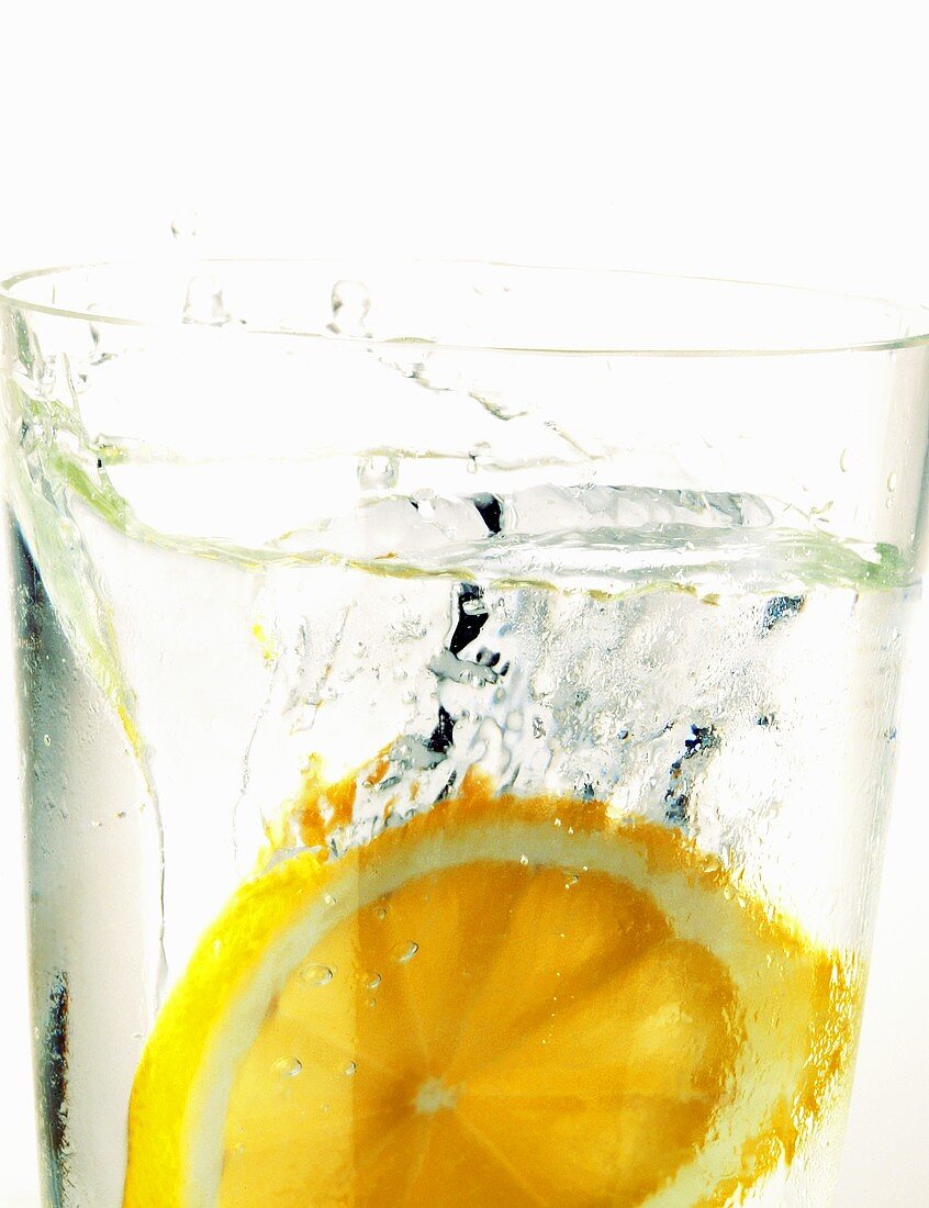 Zitrone fällt in Wasserglas (Close up)