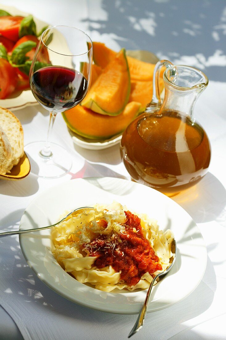 Pasta with tomato sauce; sweet melon; wine; tomato salad