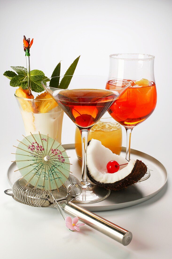 Various cocktails on tray with bar strainer & cocktail umbrella