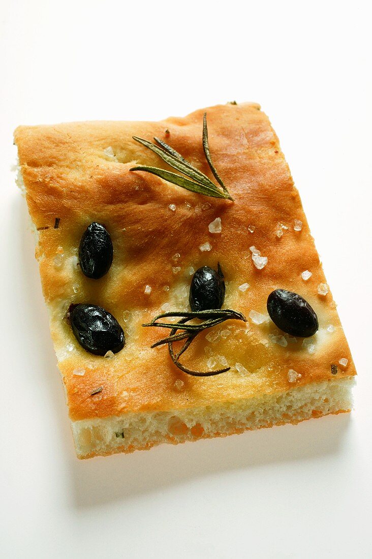 Stück Focaccia mit Oliven, Salz und Rosmarin