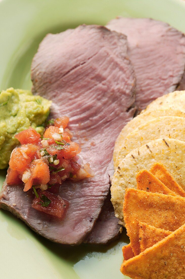 Roast beef with tomato salsa, guacamole and tortilla chips