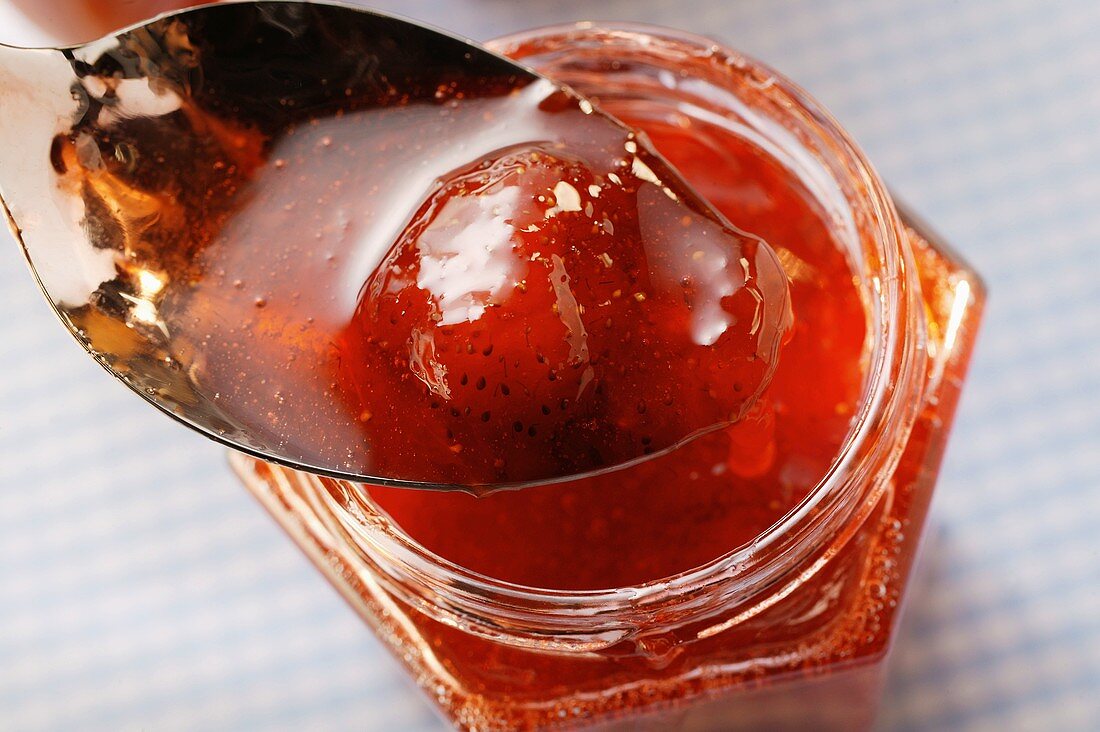 Strawberry jam in jar and on spoon