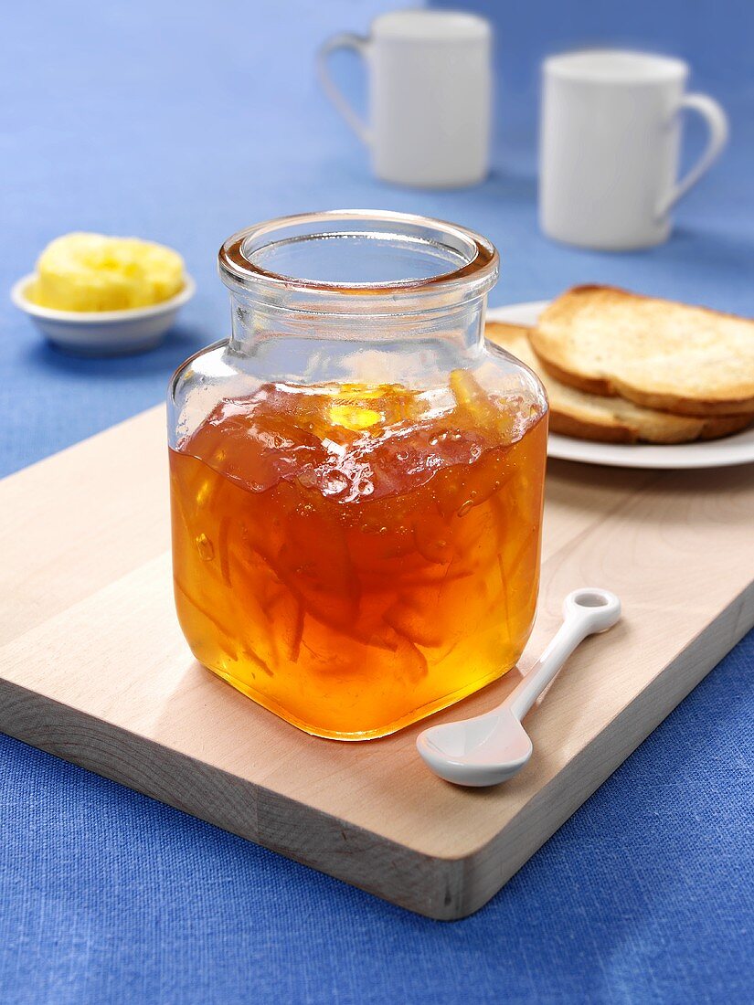 Jar of orange marmalade, toast and butter