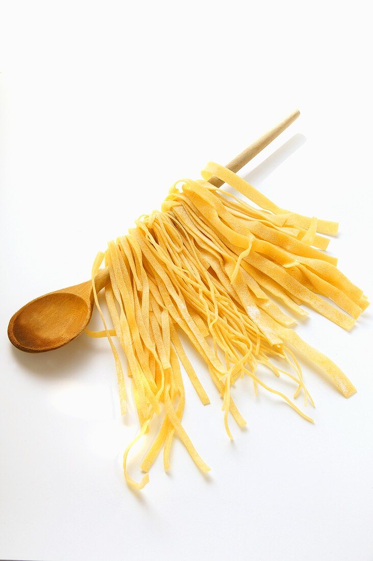 Home-made pasta hanging on kitchen spoon