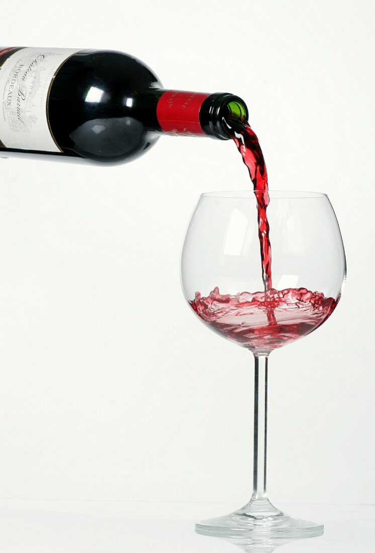 Rosewein aus Flasche in Glas gießen