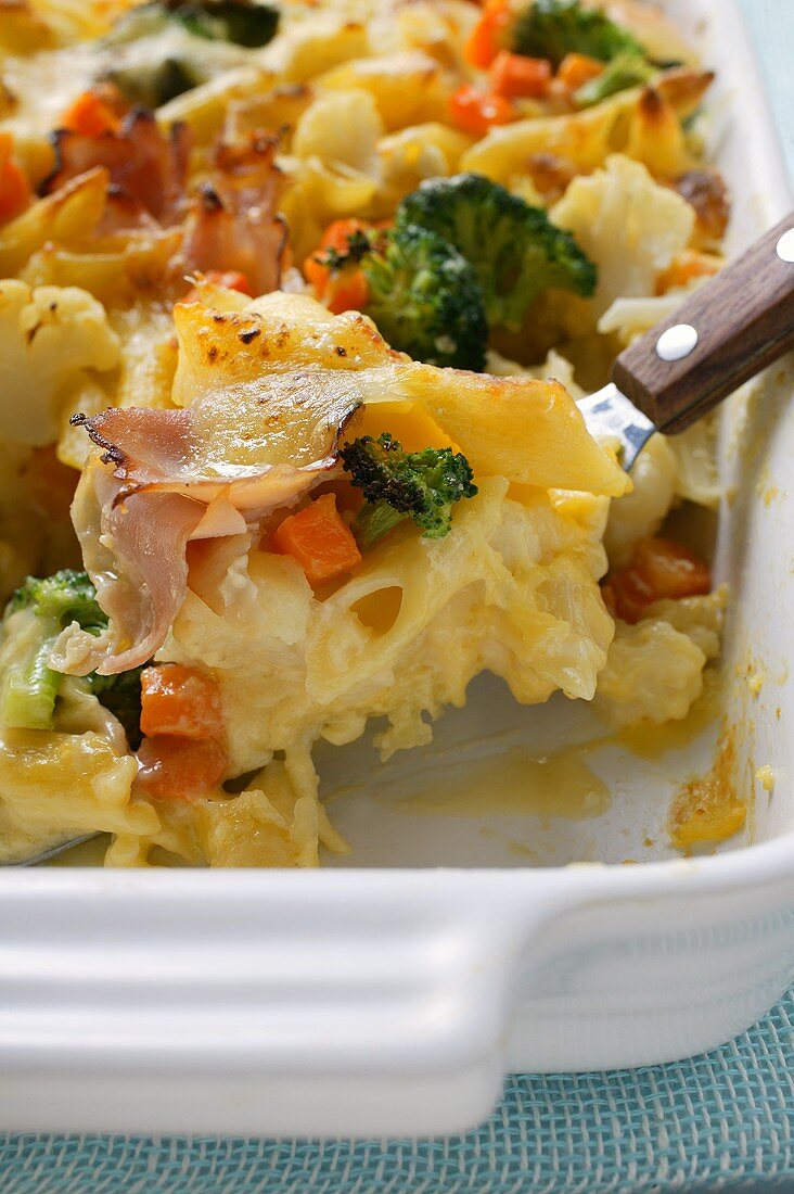 Pasta bake with ham, carrots, broccoli and cheese