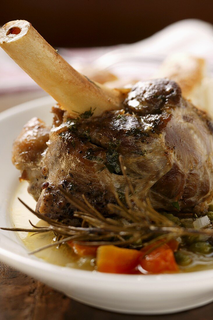 Braised lamb shank with vegetables & rosemary on plate