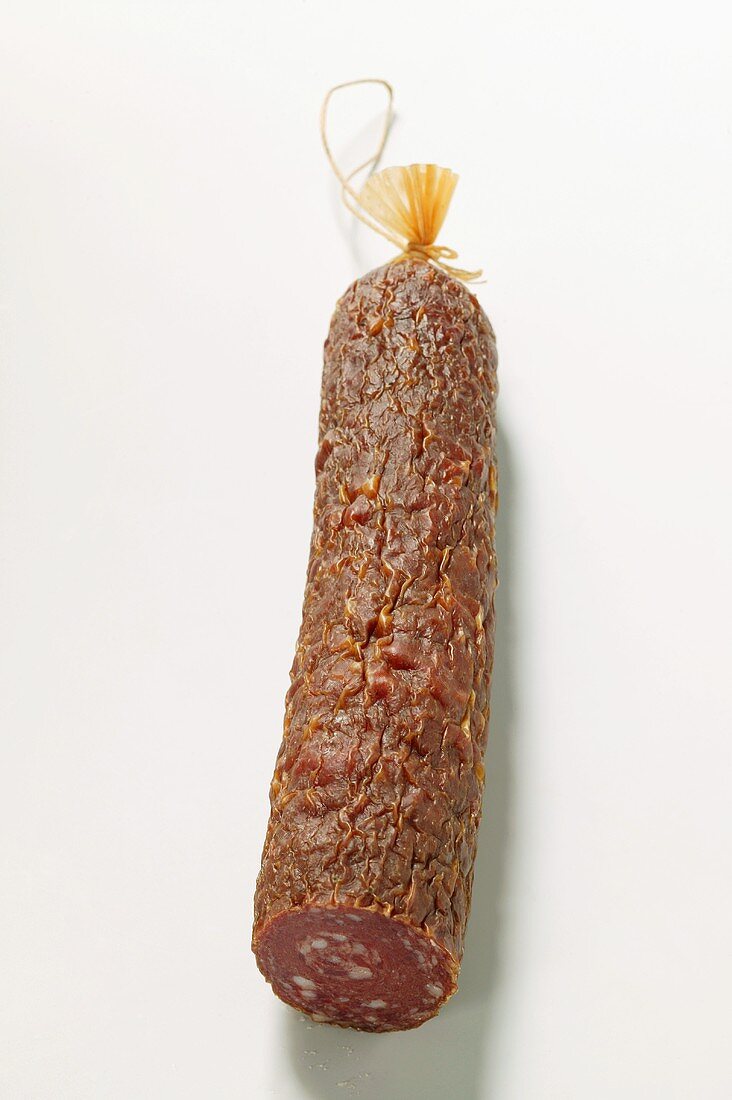 Eine Stange Wildwurst (Salami), angeschnitten