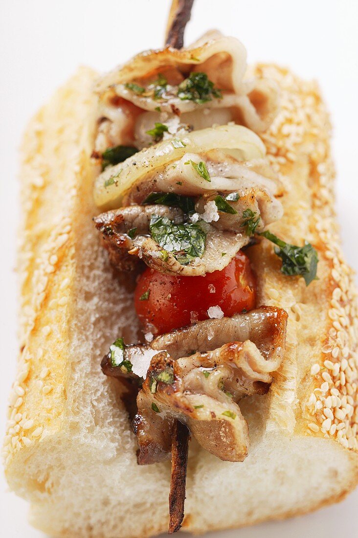 Barbecued pork kebab on sesame baguette