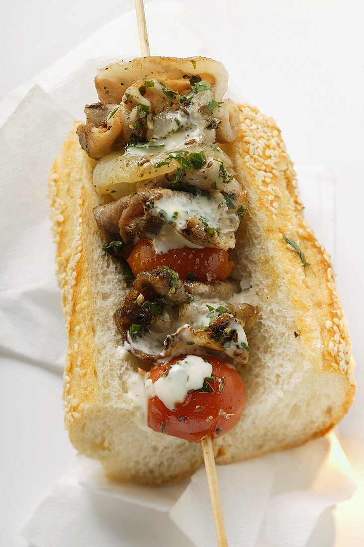 Barbecued pork kebab on sesame baguette