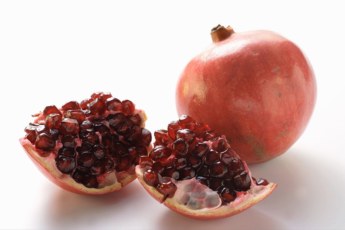 Two pomegranates, one halved