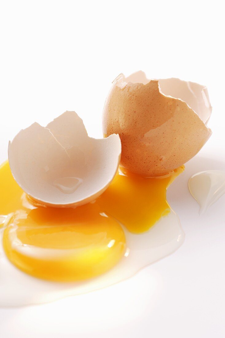 Egg yolk and eggshells on white background