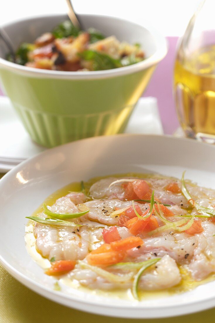 Carpaccio aus rohen Garnelen, Tomaten und Frühlingszwiebeln