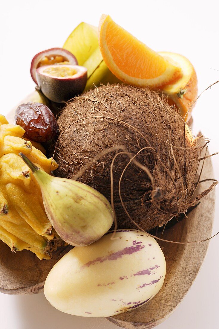 Exotisches Früchtestilleben mit Kokosnuss in Holzschale