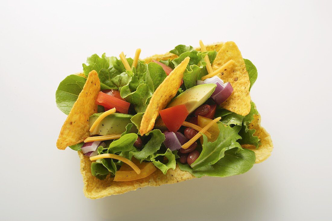 Mexikanischer Salat mit Gemüse und Tacochips in Taco-Shell