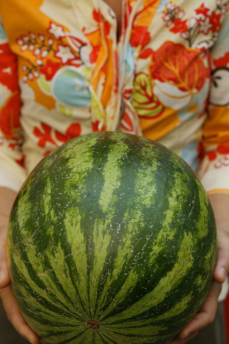 Woman holding large watermelon