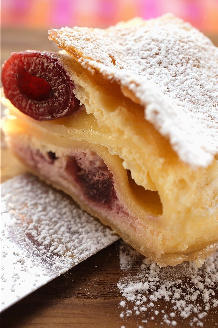 Piece of cherry strudel with icing sugar