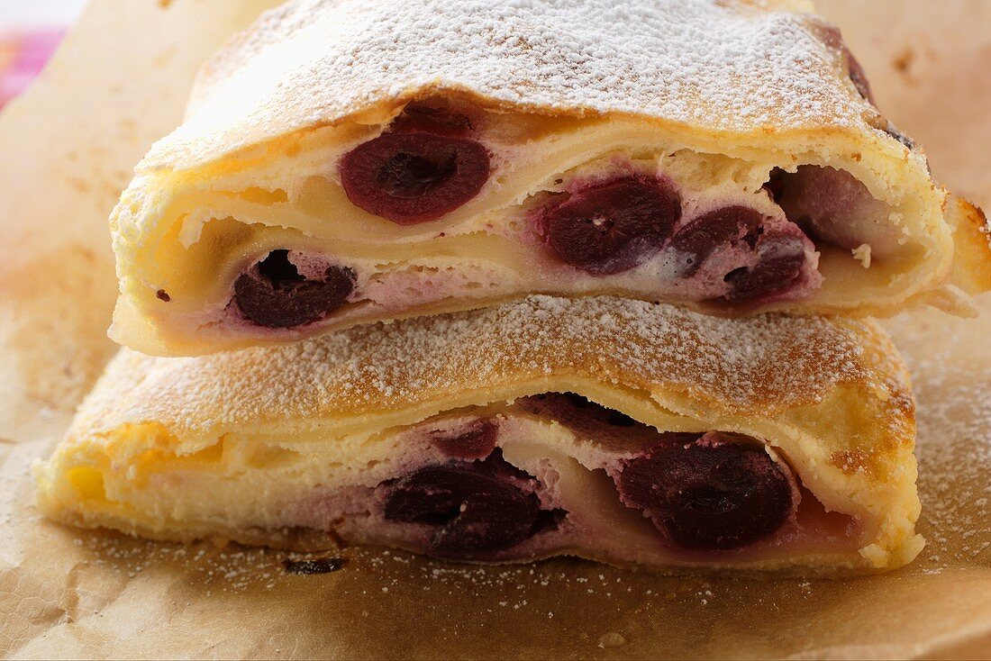 Two pieces of cherry strudel with icing sugar