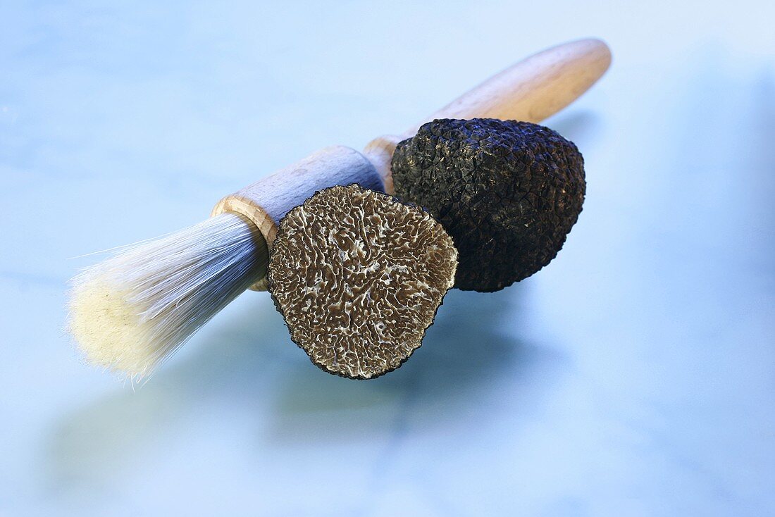 Black truffle, halved, with truffle brush
