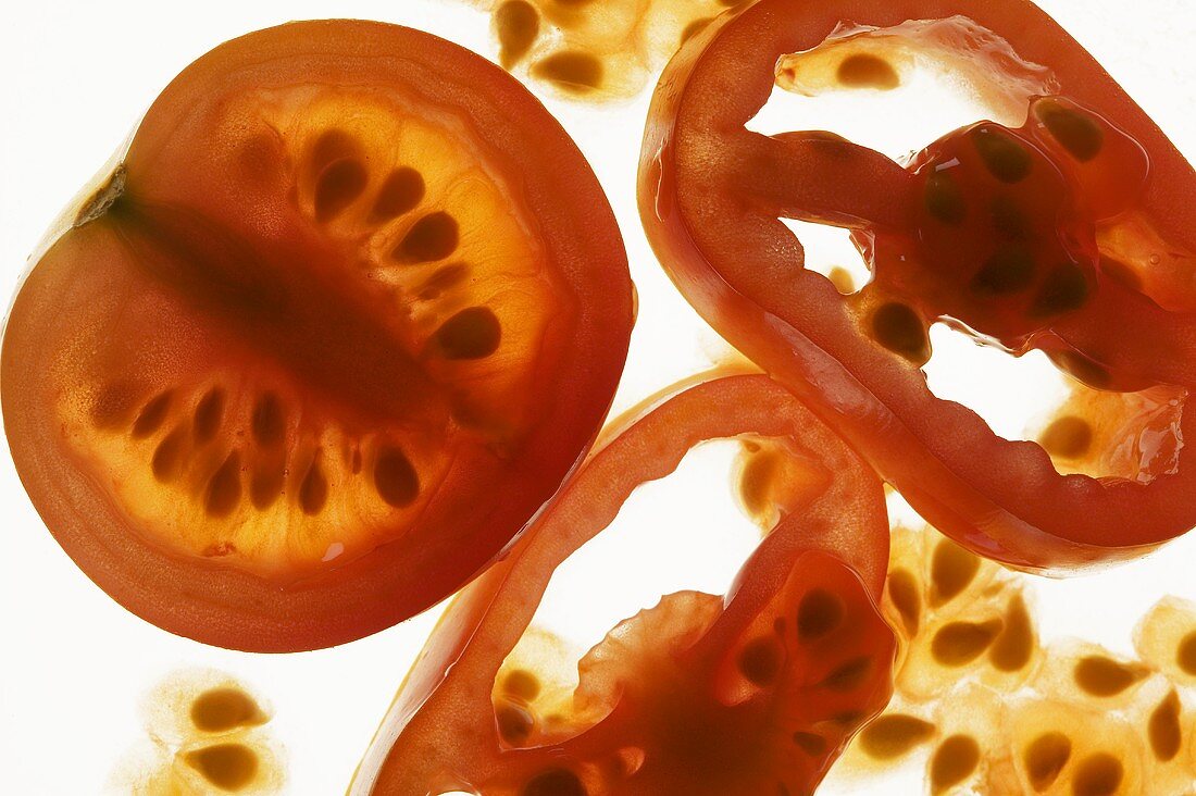 Tomato half and tomato slices, backlit