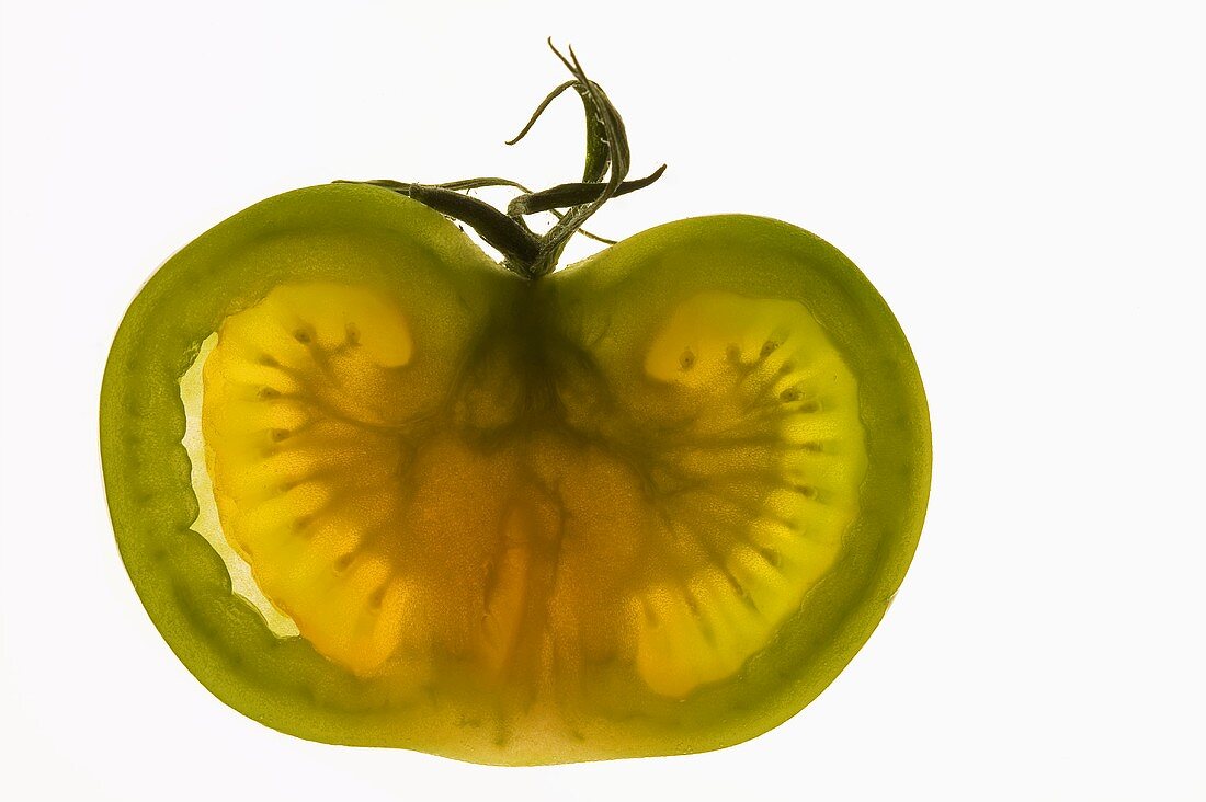 Half a green tomato, backlit
