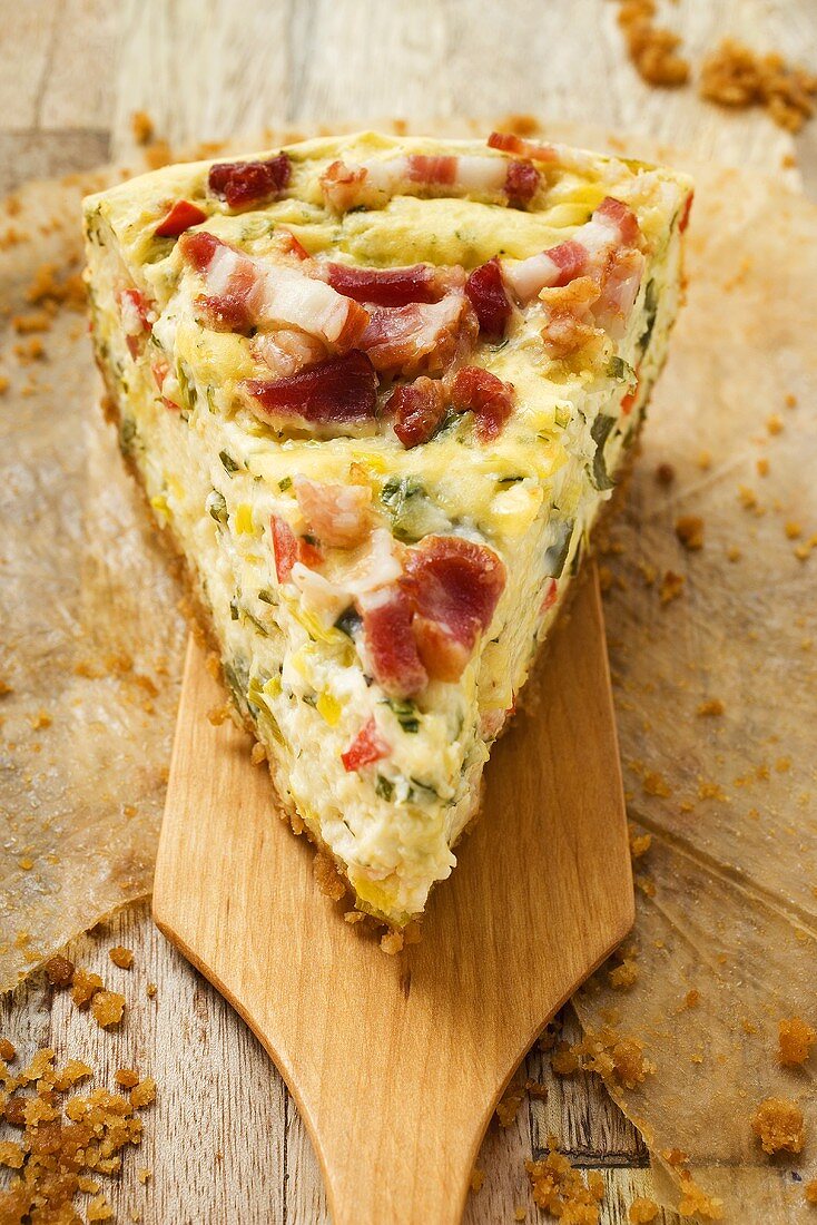Piece of leek and bacon quiche on server