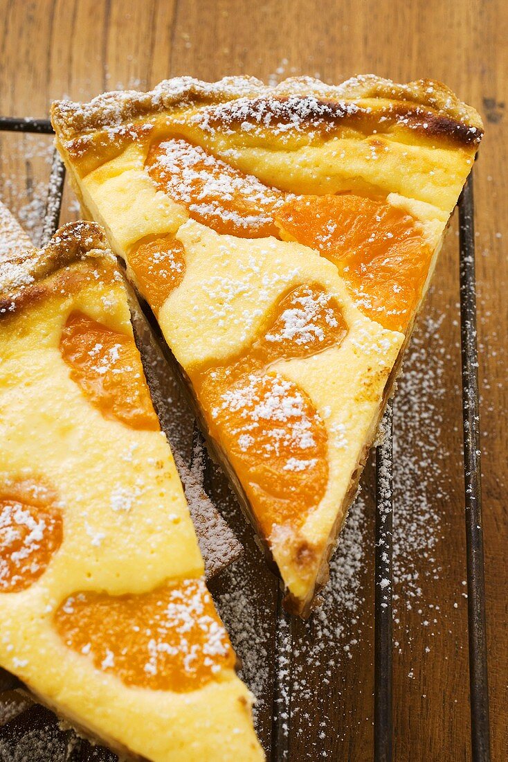 Two pieces of apricot tart with icing sugar