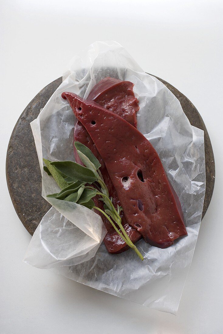 Two slices of calf's liver with sage on paper