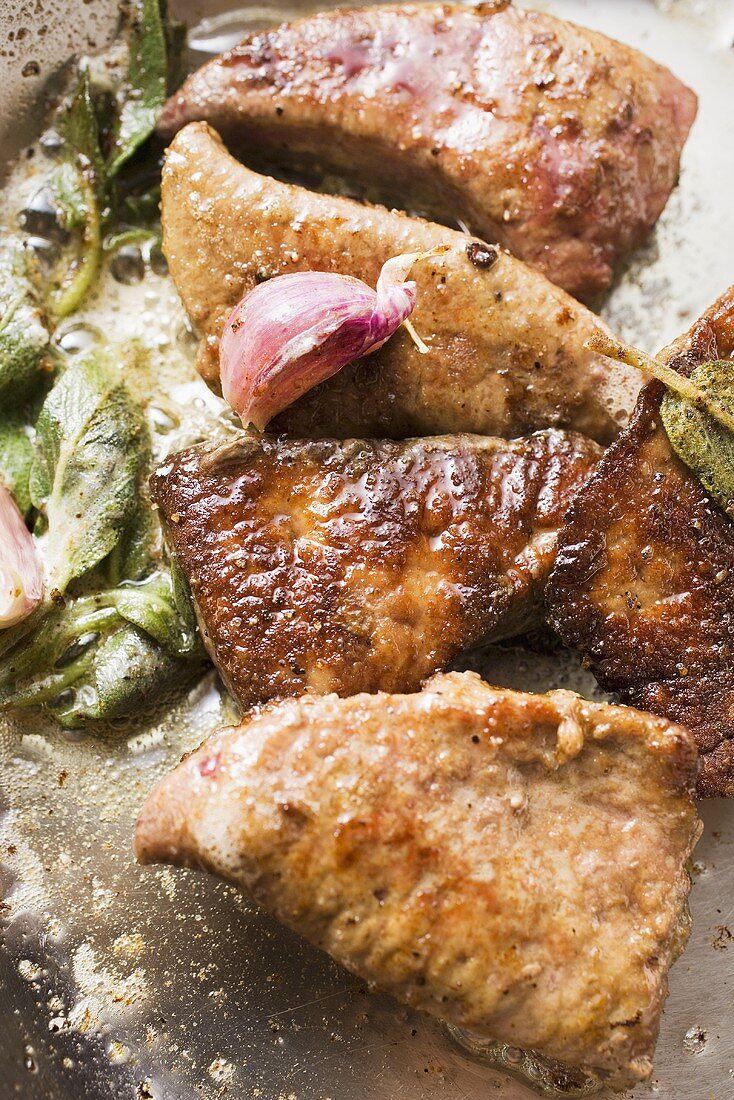 Fried calf's liver with sage and garlic in frying pan