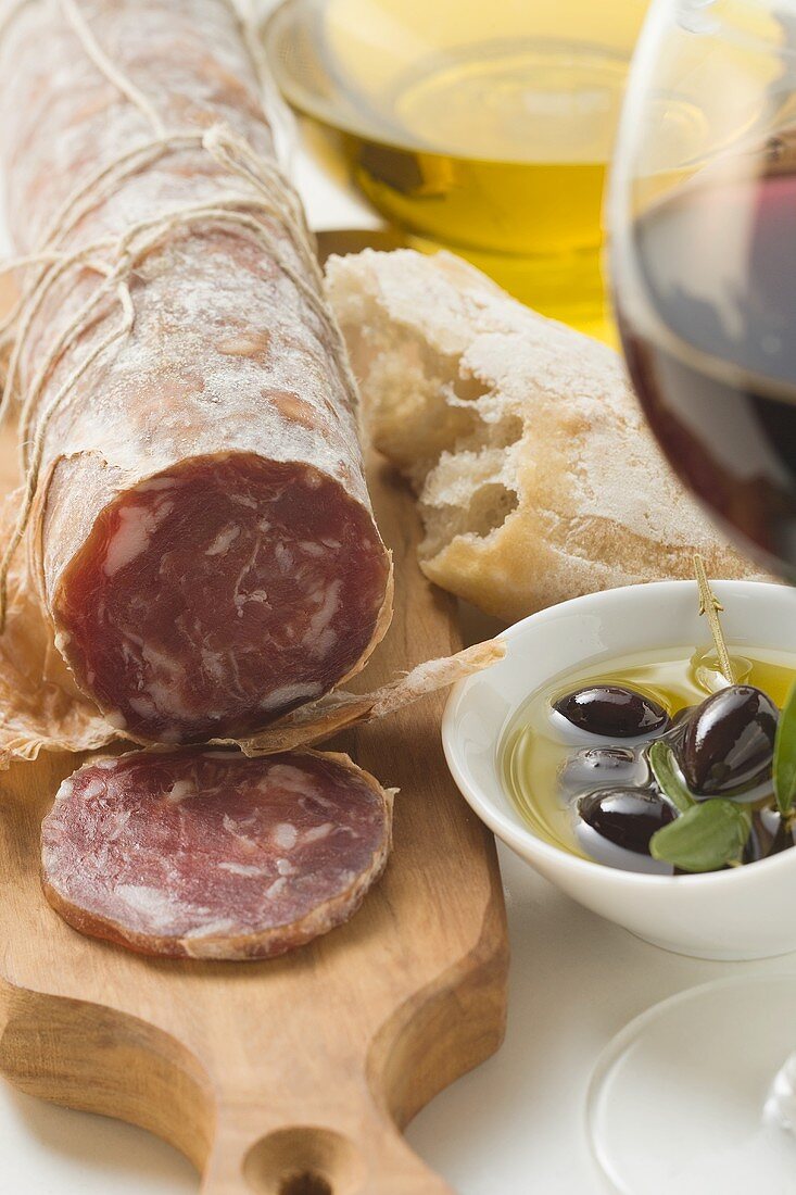 Italienische Salami, Oliven in Olivenöl, Weißbrot