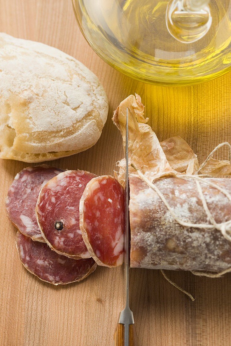 Italian salami with slices cut, white bread, olive oil