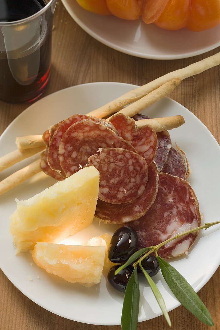 Salami, Käse, Oliven und Grissini auf Teller