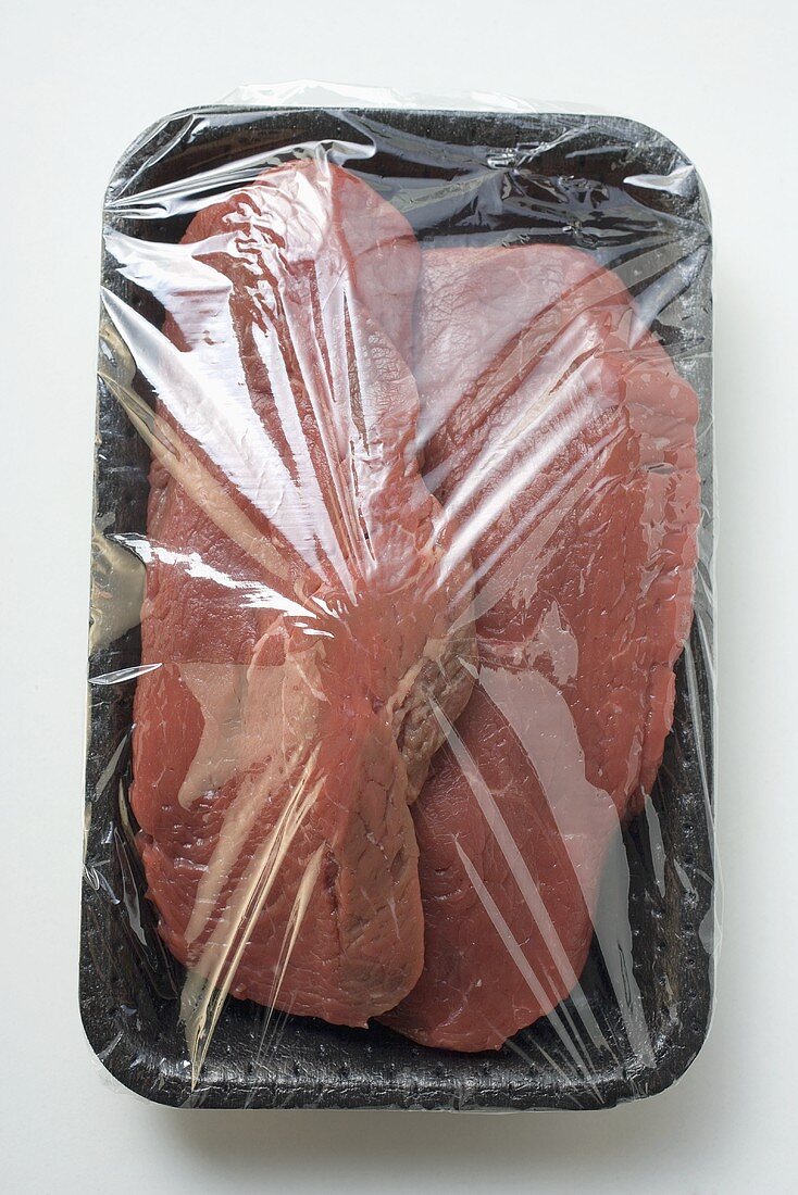 Two slices of beef sirloin, in packaging