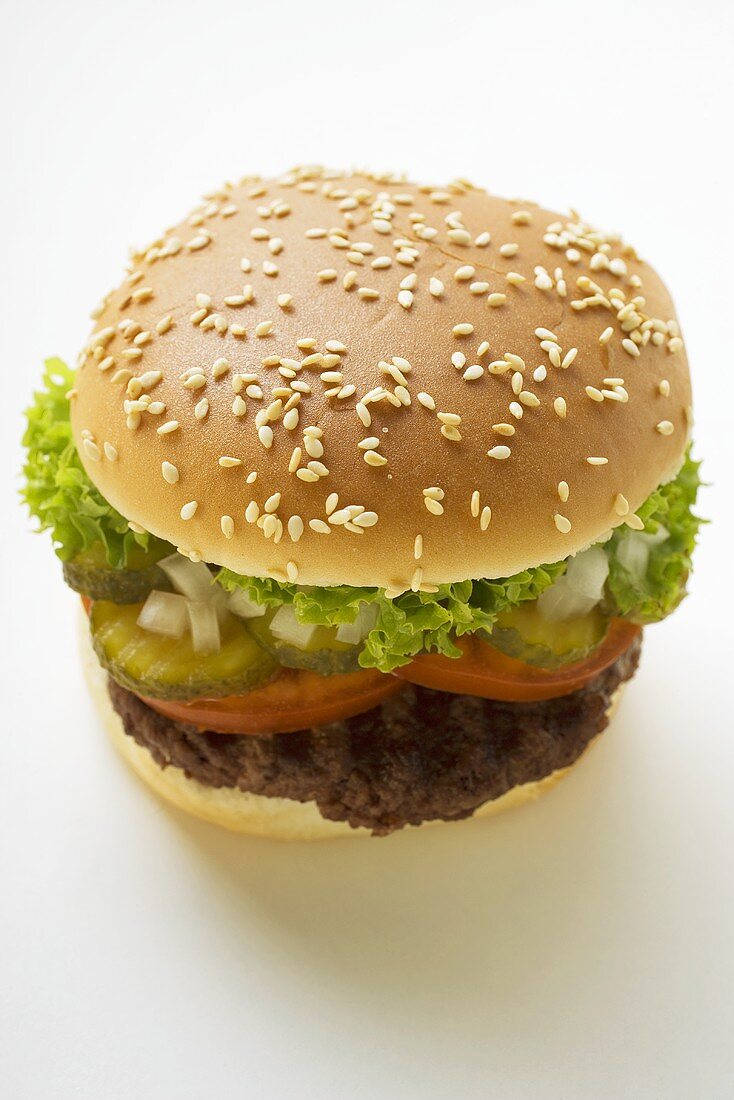 Hamburger with tomato, gherkin, onions and lettuce