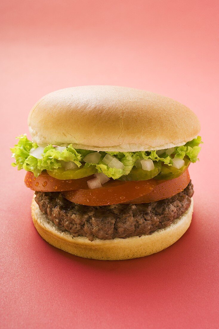 Hamburger mit Tomate, Gewürzgurke, Zwiebeln und Salat